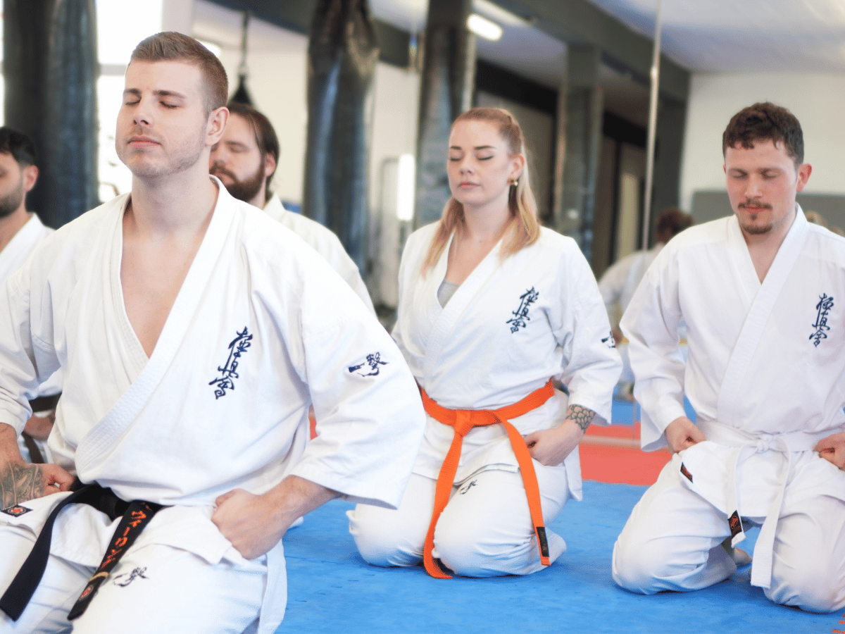 Kniende Karateka, die Karate für Fitness machen, Karate für Erwachsene